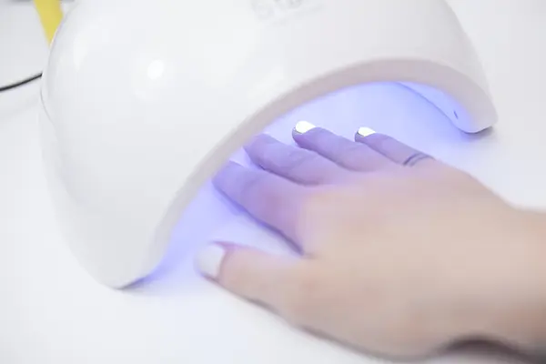 Lámpara de luz UV/LED y manos.